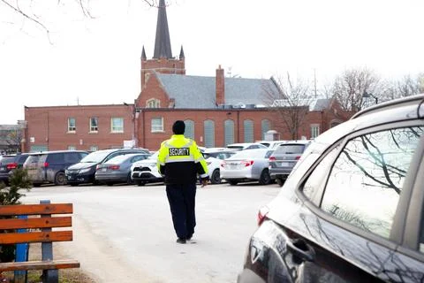 Security guard with caution tape to do parking enforcement at guest parking lot. 스톡 사진