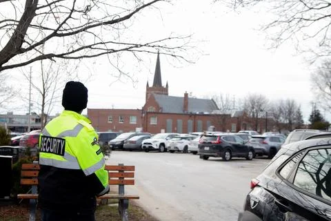 Security guard with caution tape to do parking enforcement at guest parking lot. Stockfoto's