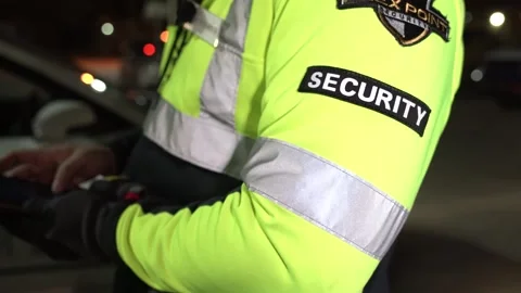 Security guard is checking his patrol fleet vehicle car with mobile digital repo Stock Footage 256489281