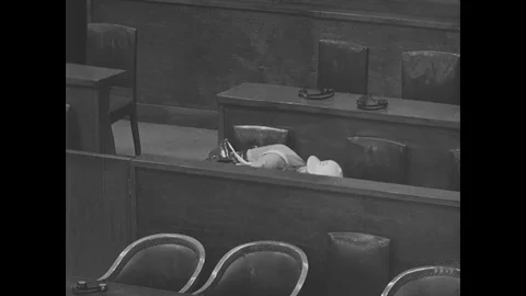 Security guard checks the empty courtroom during war crimes trials - 1947 Stock Footage 92683566