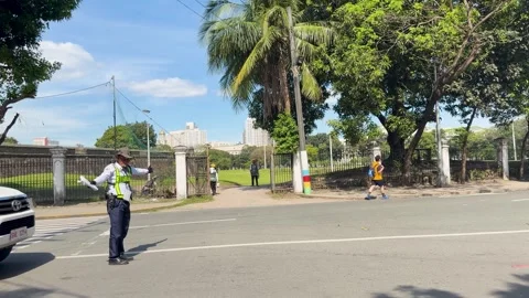 Security Guard Directing Traffic and Pedestrians Near Manila Park Entrance Stock Footage 333364367