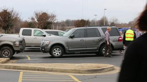 Security Guard greets people arriving in parking lot Video stock 46462953