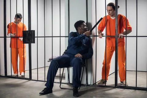 A security guard in a high-security prison threatens a prisoner in solitary Stock Photos