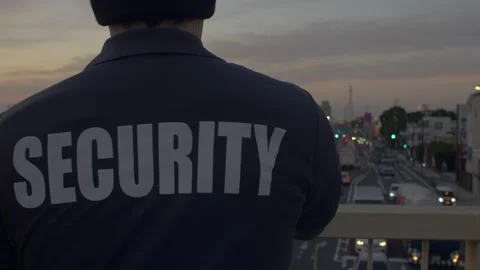 Security guard looking down and patrolling the street and sunset Stock Footage 153888458