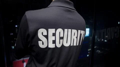 Security guard looking down the cityfull of lights at night. 스톡 사진