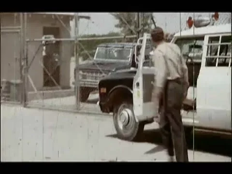 Security guard opening gate at military base to let car out, 1970s 스톡 동영상 65860764