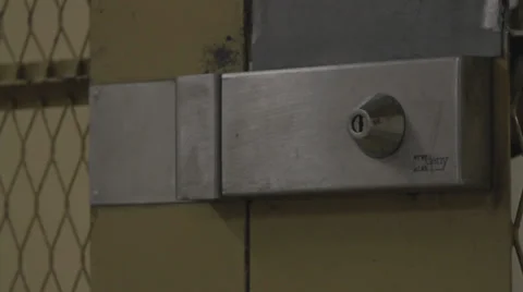 SECURITY GUARD PASSES THROUGH PRISON DOOR Stock Footage 28071443