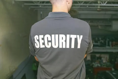 Security guard patrolling inside warehouse of tires. Stock Photos