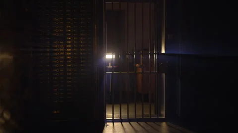 Security guard patrols dark vault with a flashlight for safety and Vídeos de archivo 276419371