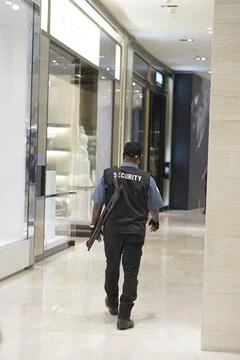 Security guard with pump gun doing checking at shopping mall Stock Photos