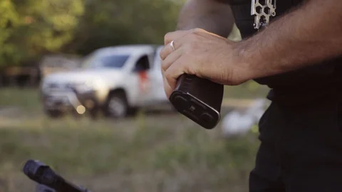 The security guard puts bullets into the magazine for machine gun and pistol Stock Footage 95178652