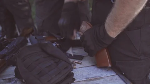 The security guard puts bullets into the magazine for machine gun and pistol Stock Footage 95182560