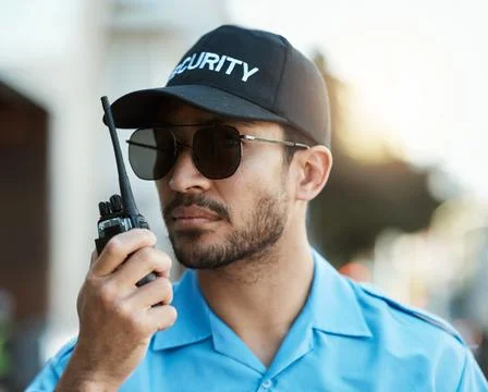 Security guard, safety officer or man with a walkie talkie outdoor on a city Stock Photos