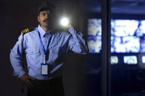 Security guard searching with torch light while working at night Stock Photos