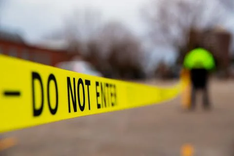 Security guard setting up a caution tape to do parking enforcement at guest park Stock Photos