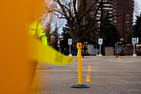 Security guard setting up a caution tape to do parking enforcement at guest park Stockfoto's