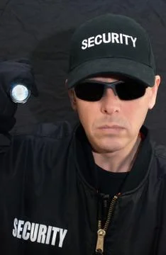 Security guard shines flashlight at the camera Stock Photos