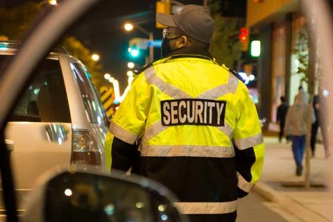 Security guard standing by next to security car at night city Stock Photos