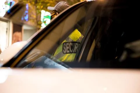 Security guard standing by next to security car at night city 스톡 사진