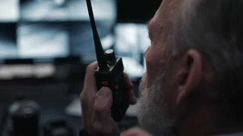 Security Guard Using Radio Communication in Surveillance Control Room Stock Footage 324025984