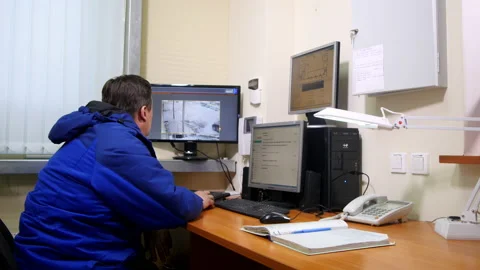 Security guard watches situation from surveillance cameras Stock Footage 238467627