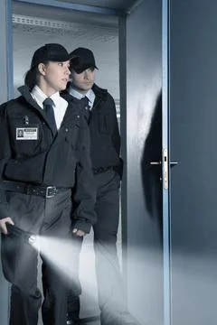 Security guards with flashlight entering parking garage Stock Photos