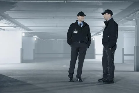 Security guards talking in empty parking garage Stock Photos