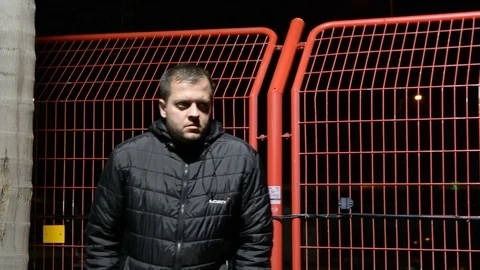 Security man at cold night. man in the hood warms up on the bench at night. Stock-Footage 104872869