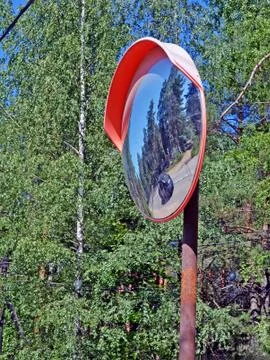 Security mirror reflecting twisting highway and the car Stock Photos