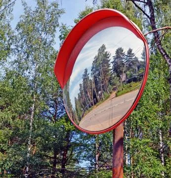 Security mirror reflecting twisting highway Stock Photos
