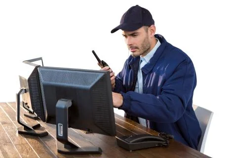 Security officer looking at computer monitors and talking on walkie-talkie Stock Photos