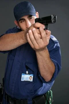 Security Officer takes aim Security guard taking aim with gun. Please note... Stock Photos
