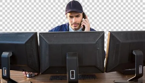 Security officer talking on phone while using computer at desk Stock Photos