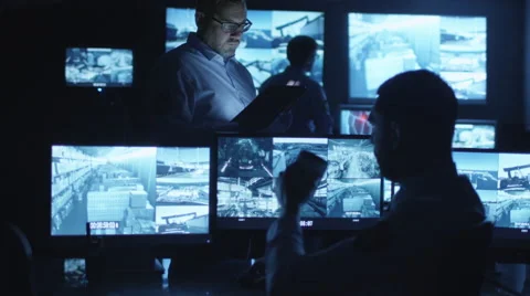 Security officer is using a tablet computer in a dark monitoring room 스톡 동영상 59608533