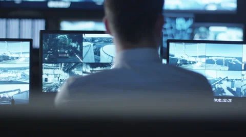 Security officer is working on a computer in a dark monitoring room Stock Footage