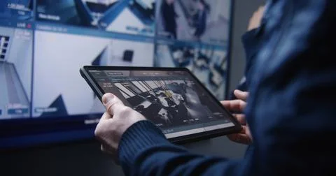 Security operator zoom CCTV cameras using tablet Foto stock