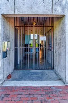 Security panel and closed metal gate at the concrete building entryway of school Fotos de archivo