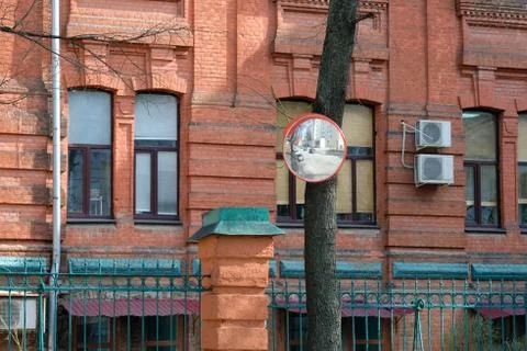 Security panoramic mirror mounted on a tree trunk in the city. Stock Photos