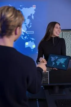 Security professionals collaborating in a technical workspace with threat maps Photos