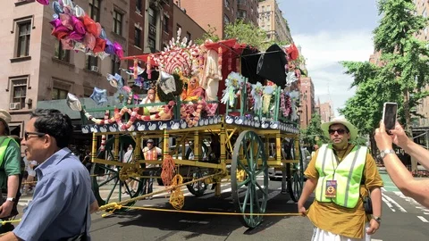 Security pulling rope parade float at Hare Krishna march on 5th Ave in NYC Stock Footage 112081297
