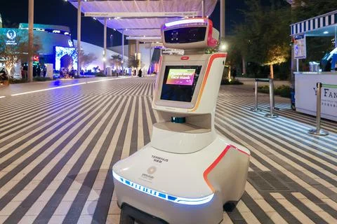 Security robot keeping order at exhibition. Machine ask to wear on face mask in Stock Photos
