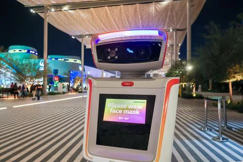 Security robot keeping order at exhibition. Machine ask to wear on face mask in Foto stock