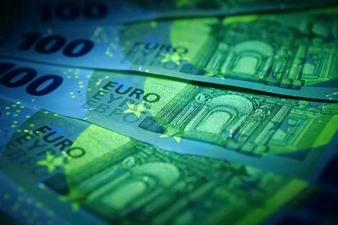 Security signs and elements on euro banknotes glow under ultraviolet light Foto stock