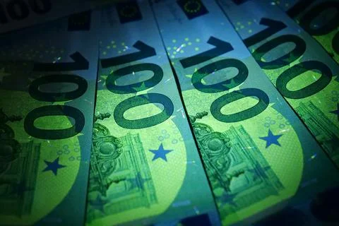 Security signs and elements on euro banknotes glow under ultraviolet light Foto stock