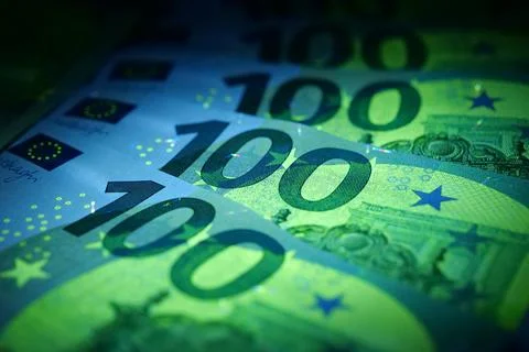 Security signs and elements on euro banknotes glow under ultraviolet light Foto stock