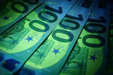 Security signs and elements on euro banknotes glow under ultraviolet light Foto stock