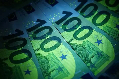 Security signs and elements on euro banknotes glow under ultraviolet light Foto stock