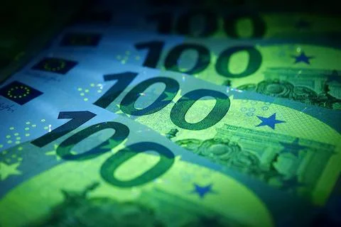 Security signs and elements on euro banknotes glow under ultraviolet light Foto stock