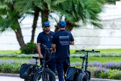 Security staff with e-bikes in garden of Royal Palace of Caserta 库存照片