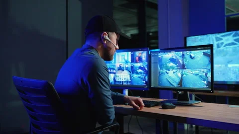 Security system operator looking at CCTV footage at desk in office Stock Footage 266467405